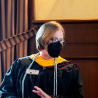 2 women faculty smiling and conversing